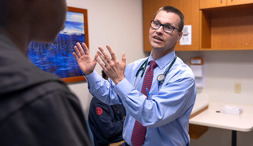 Sports cardiology physician with patient